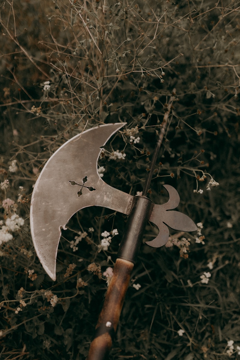 an old axe with a wooden handle laying on the ground